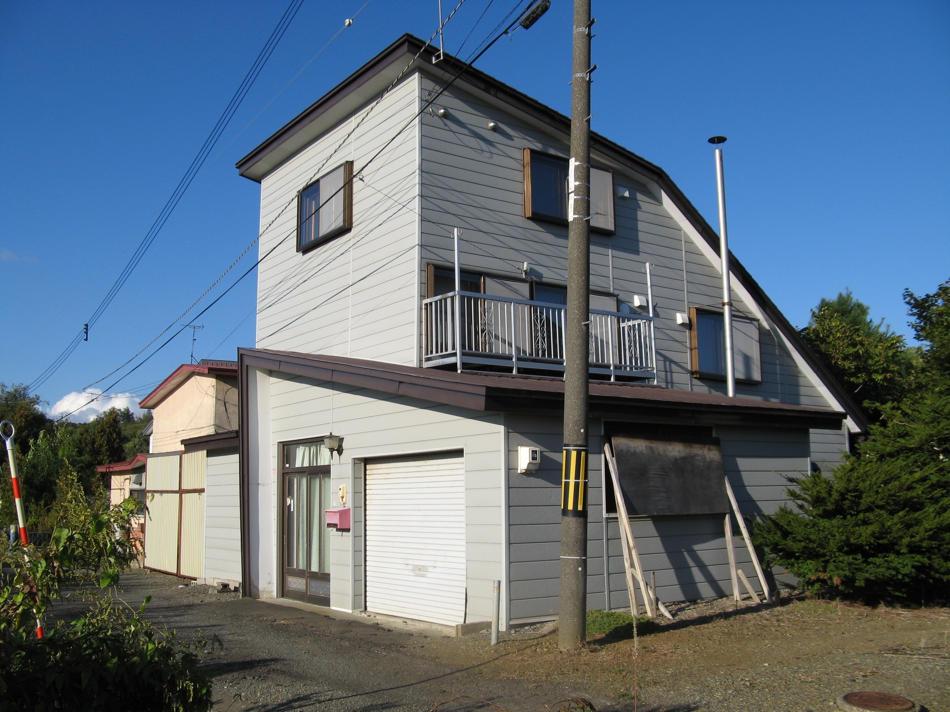 青空に映えるスタイリッシュな二階建て住宅