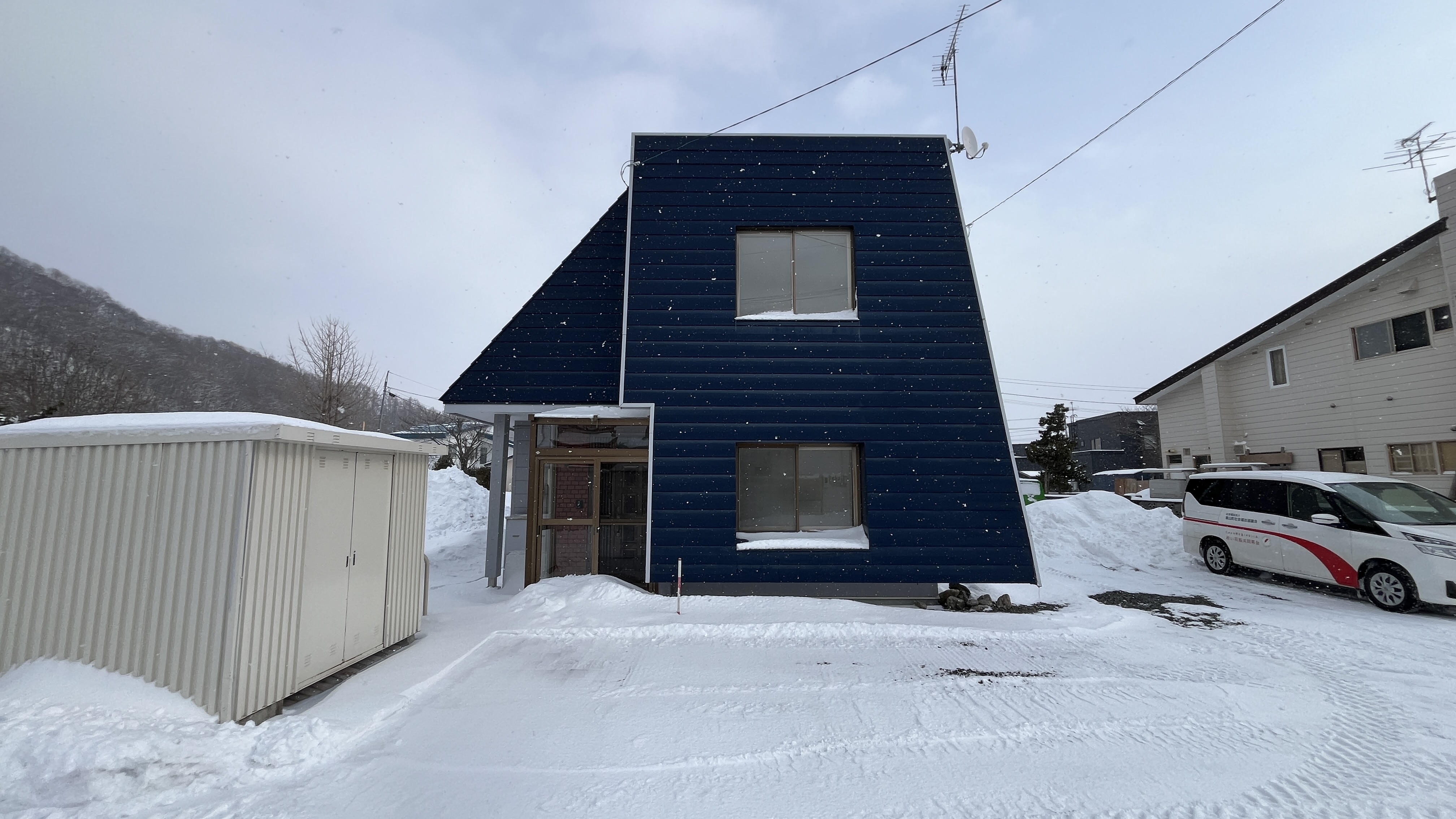 斜め壁が印象的な青い家